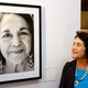 Dolores Huerta, co-founder of United Farms Workers, stands by a portrait of herself taken in 1998, at an exhibition about her life held in Los Angeles on April 10, 2014.